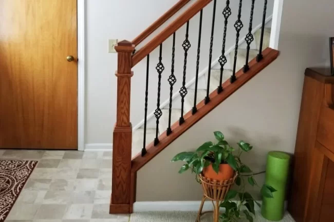 basement-staircase-railing-update-aspect-ratio-960-640 Updated basement staircase with wood railing, black metal balusters, and finished trim near the lower landing