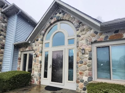 exterior-entry-door-replacement-aspect-ratio-400-300 Exterior entry with glass front door, sidelights and decorative windows surrounded by natural stone
