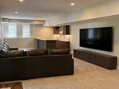 finished-basement-living-area-3-aspect-ratio-400-300 Finished basement living area with sectional seating, wall-mounted TV, media cabinet, carpet and built-in wet bar