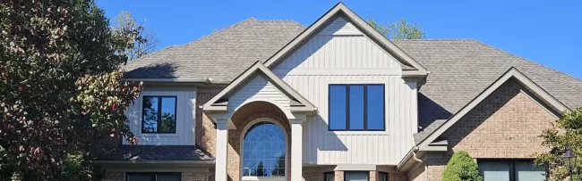 front-home-exterior-update-aspect-ratio-1920-600 Updated two-story home exterior with brick, white siding accents, black windows, and a refreshed front entry.