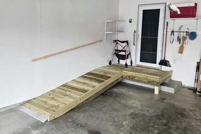 garage-access-ramp-platform-aspect-ratio-960-640 Wood access ramp and platform built inside a garage near an entry door with storage hooks and shelves