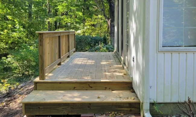 kalamazoo-deck-replacement-after-aspect-ratio-1000-600 After view of newly rebuilt wood deck with fresh deck boards, steps, and railing along the side of the home