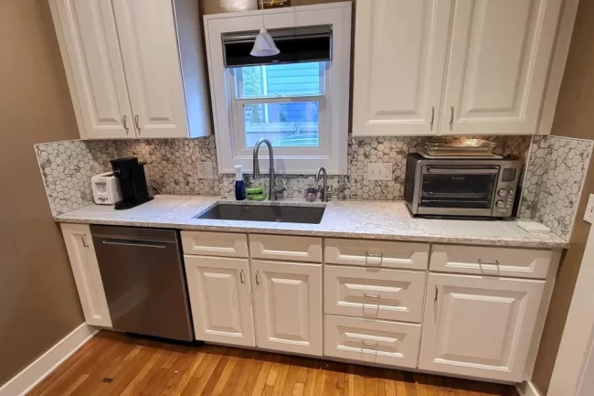 kitchen-backsplash-update-hex-tile-aspect-ratio-960-640 Updated kitchen backsplash with hex tile above white cabinets, countertop, sink, and dishwasher