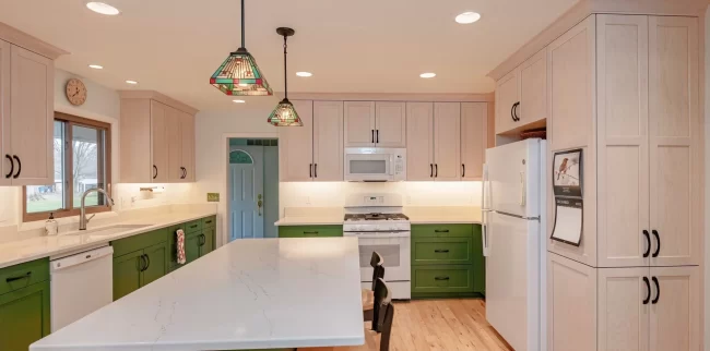 Kitchen Updates and Repairs | Pennings Handyman Updated kitchen with green lower cabinets, light upper cabinets, white countertops, island, and pendant lighting