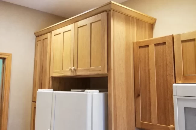 kitchen-cabinet-update-1-aspect-ratio-960-640 Custom kitchen cabinets with warm wood finish surrounding a white refrigerator