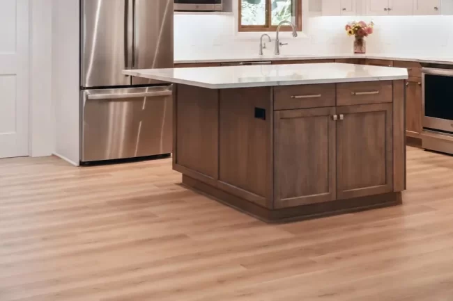 kitchen-flooring-update-aspect-ratio-960-640 Updated kitchen with new wood-look flooring, a stained wood island, white countertops, and stainless steel appliances