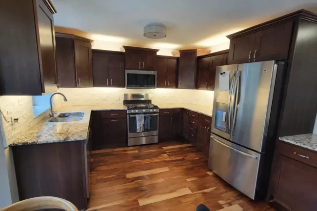 kitchen-under-cabinet-lighting-update-1-aspect-ratio-960-640 Kitchen with dark wood cabinets, new under-cabinet lighting, white backsplash, and stainless steel appliances