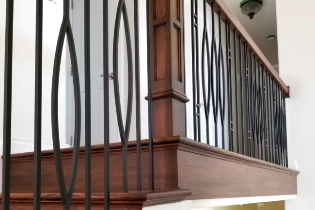 wood-stair-with-black-railing-aspect-ratio-960-640 Custom wood stair trim and railing with black metal balusters and a stained wood handrail
